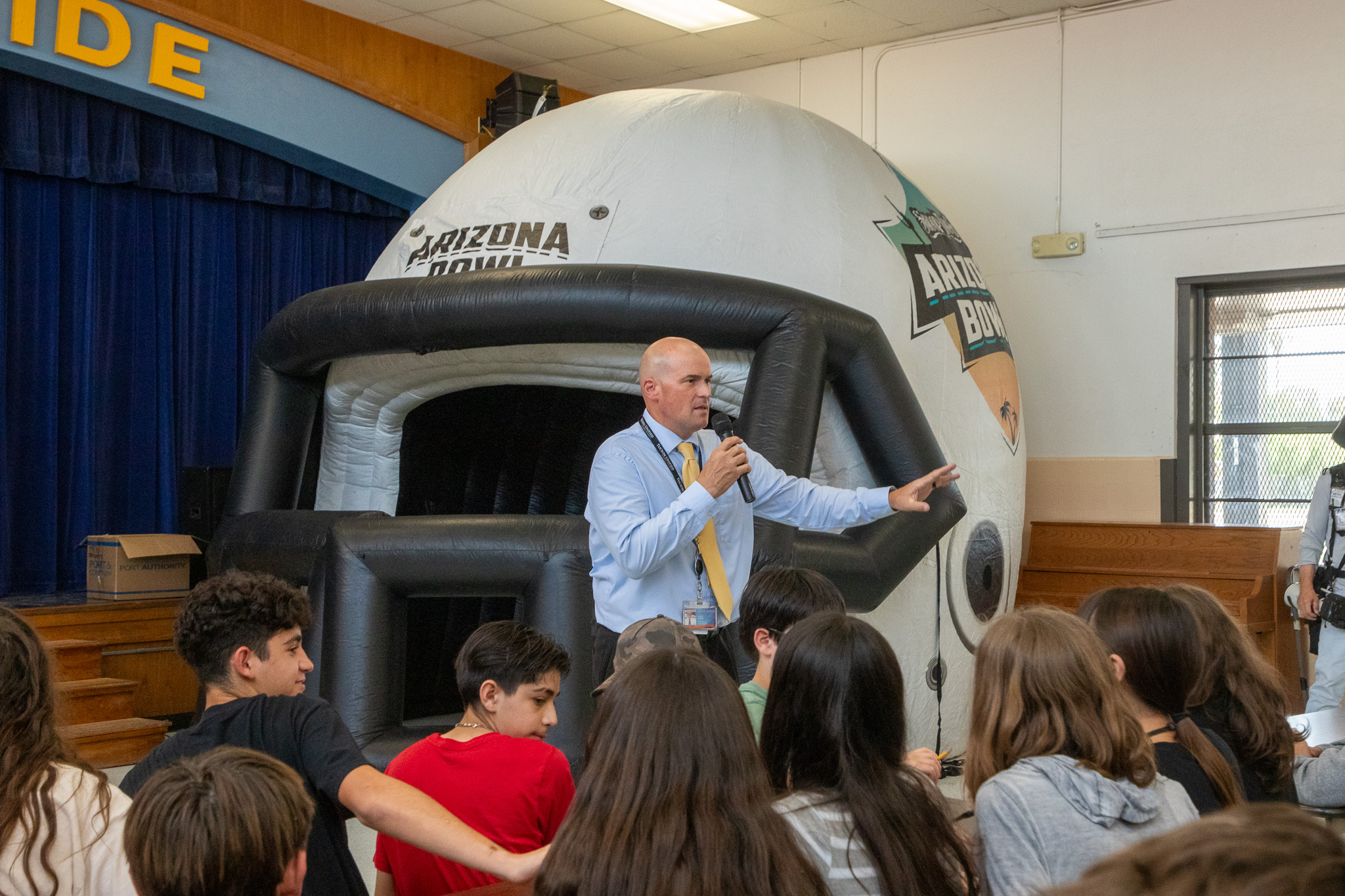 Vail's principal talks to his students in front of an inflatable football helmet