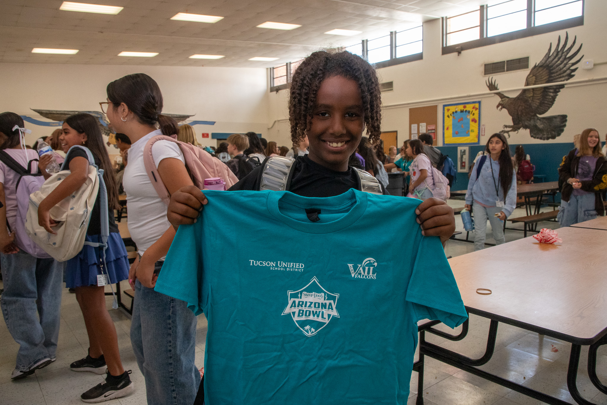 A student holds up his new t-shirt