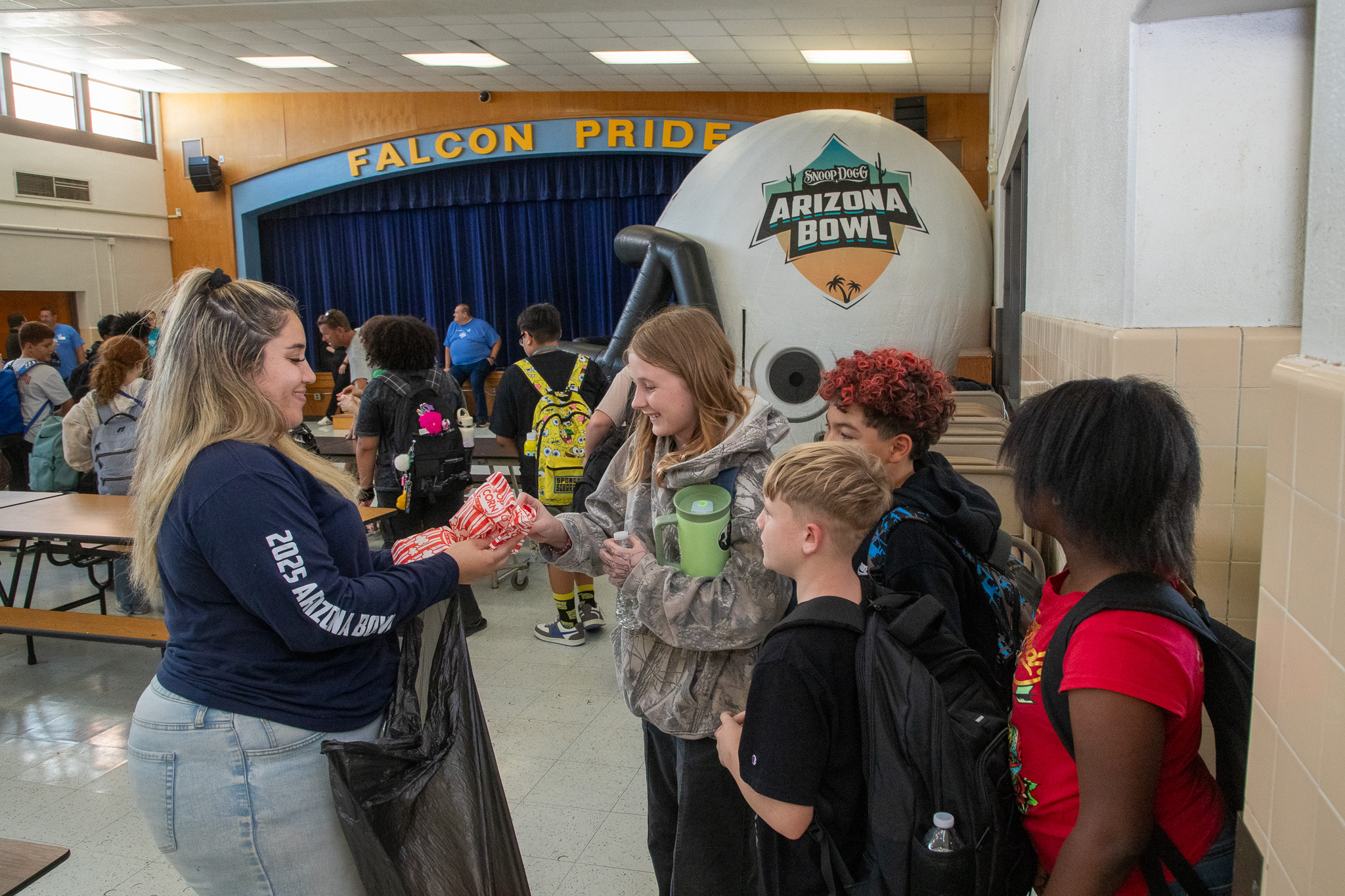 Students collect swag from a woman in the cafeteria